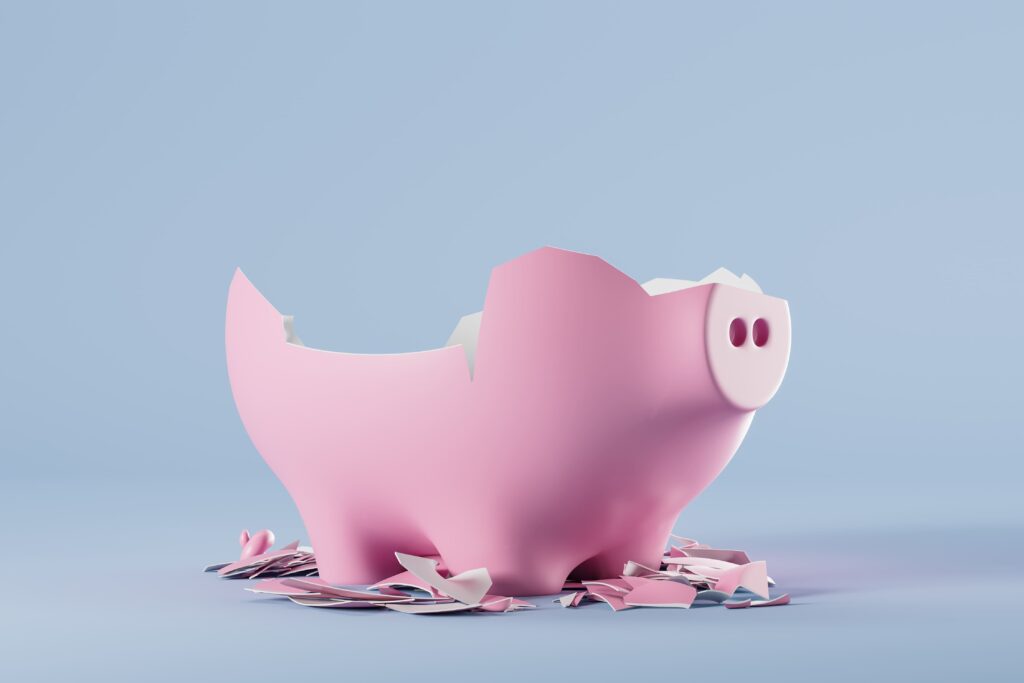 Broken piggy bank, empty inside, smashed on light blue background.